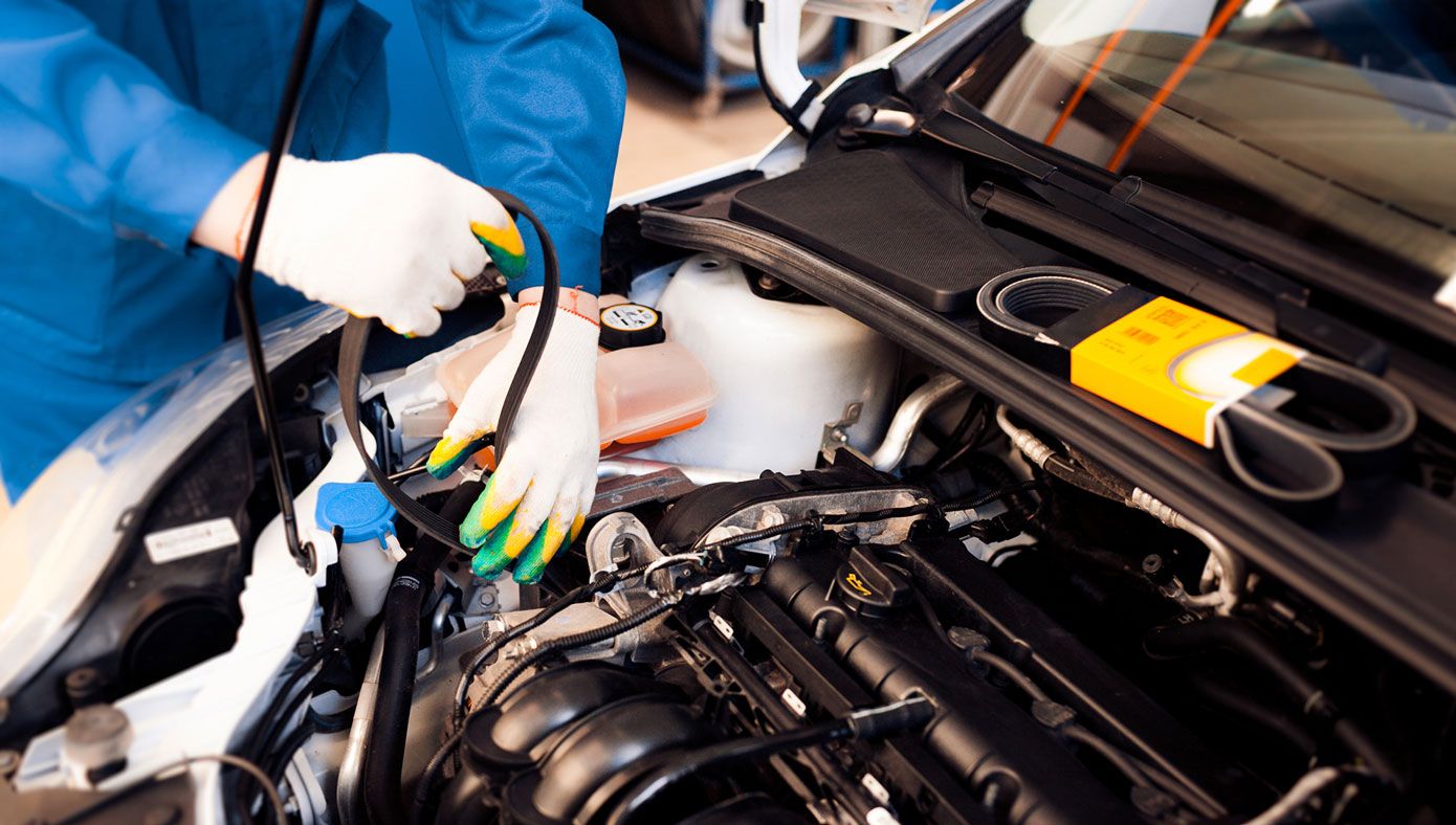 a mechanic making repairs to a car engine